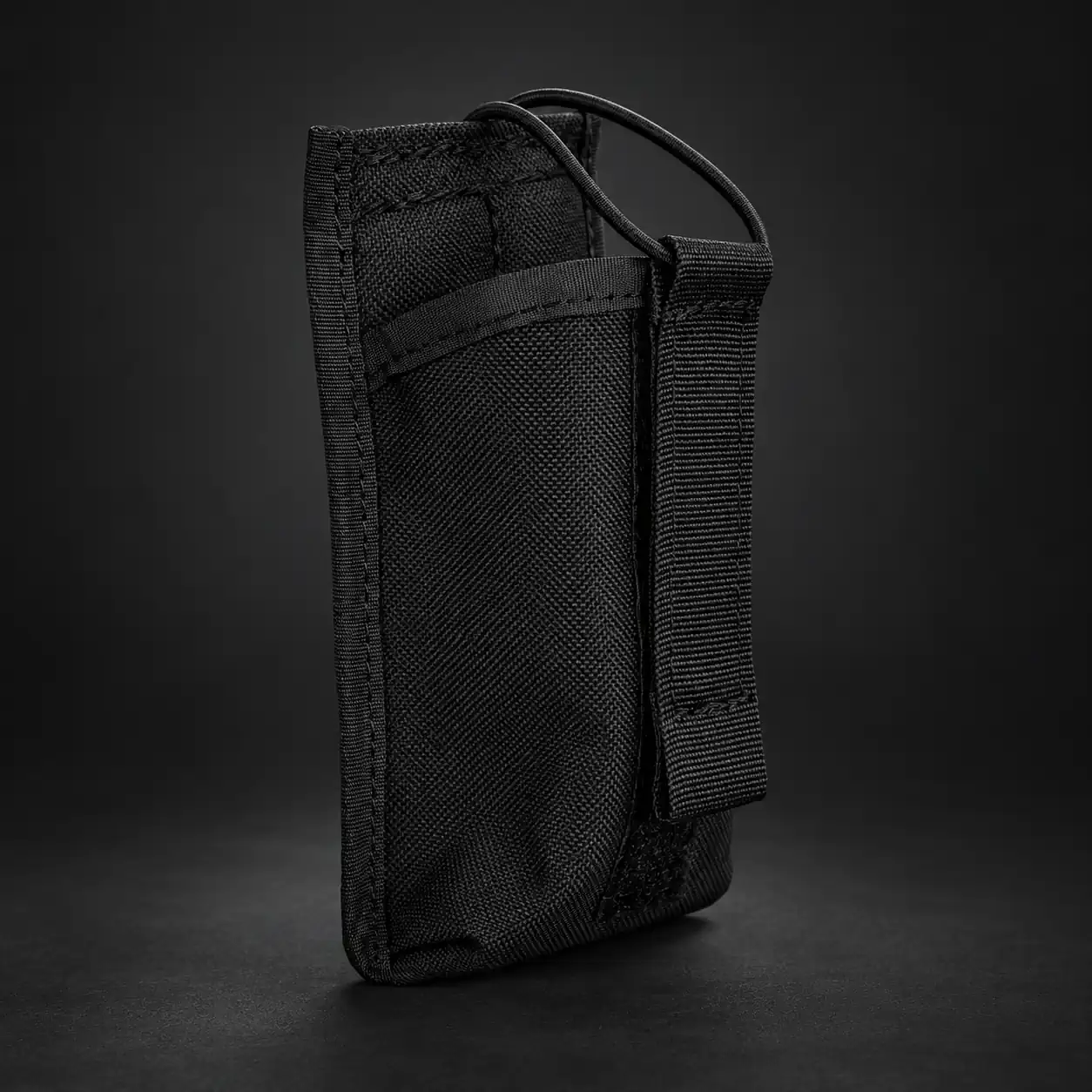 Künstlich erzeugter Inhalt: Funkgerätetasche Midi Koppel in Schwarz Künstlich erzeugter Inhalt: Funkgerätetasche Midi Koppel in Schwarz vor dunklem Hintergrund