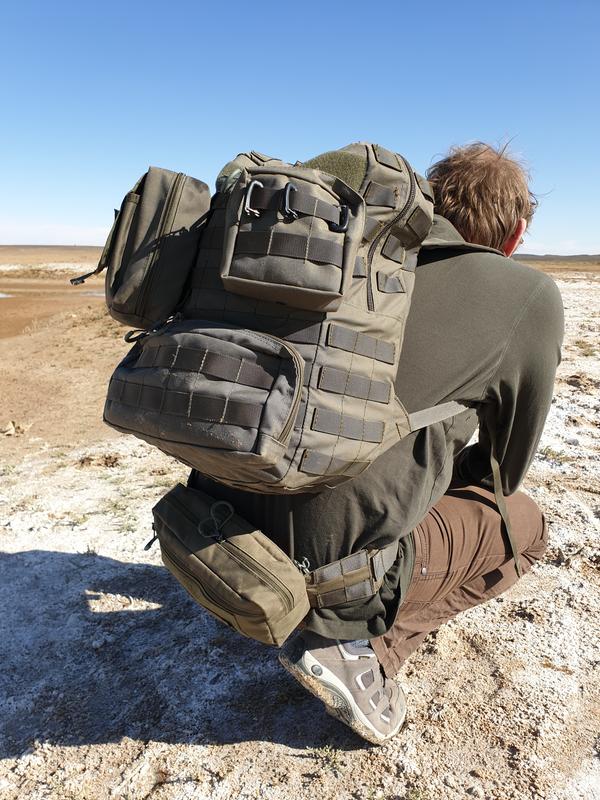 Military backpack with additional pockets in a dry lake