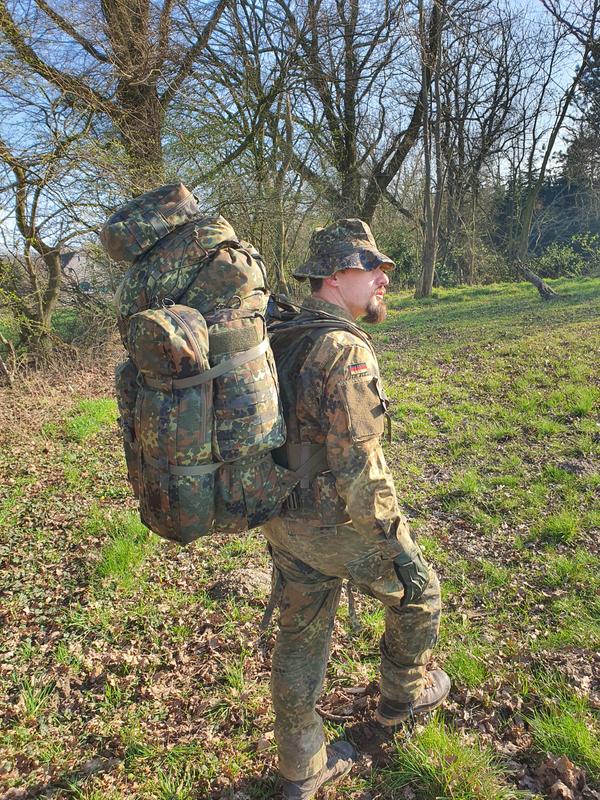 Military backpack in Flecktarn with Molle system to which are attached additional pouches
