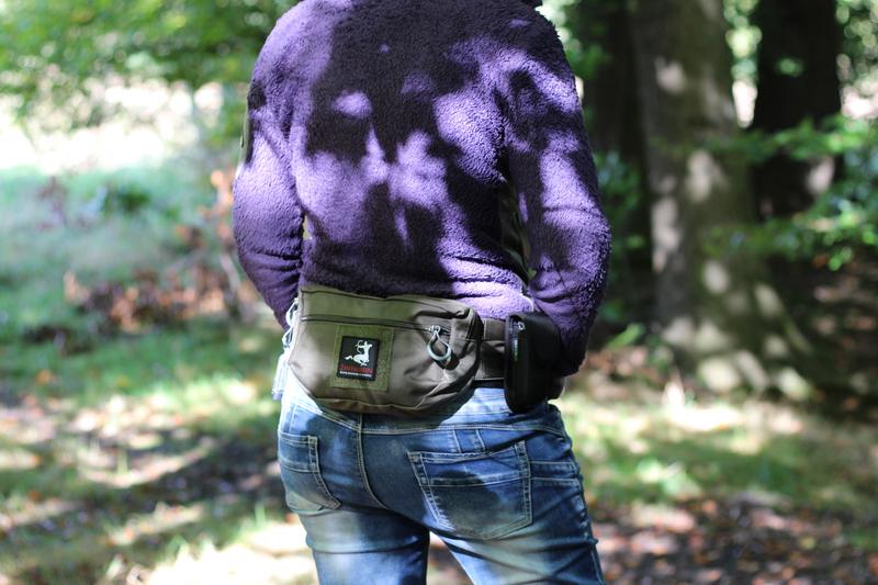 Eine Frau im Wald von hinten fotografiert mit Hüfttasche EDC nach hinten umgeschnallt.